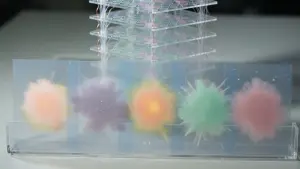 A layered acrylic structure holds glowing, colourful spherical forms resembling neural network nodes, set against a dark background.