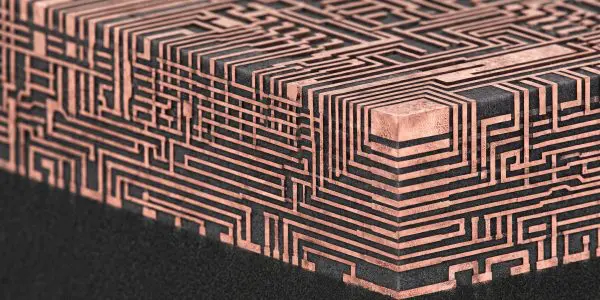 a dark block covered in raised copper traces stepping down in layers like a chip interconnect