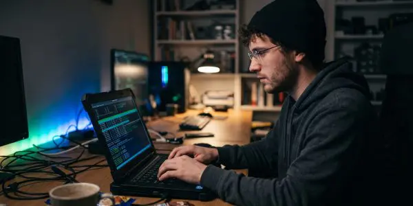 A person working at a laptop in a dim room
