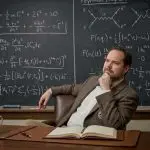 Illustration of Ben Varcoe, Leeds quantum physicist, seated at a desk in front of a chalkboard