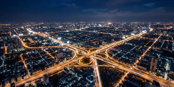 Aerial night view of a sprawling city with glowing highway interchanges