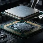 A metal heat spreader lifted above a processor bedded in thermal compound
