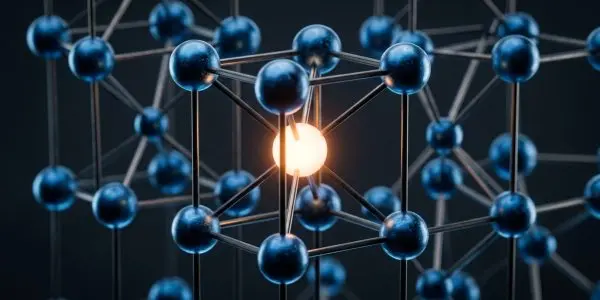 A crystalline lattice of connected spheres glows with internal light, set against a dark, blurred background, in shades of blue and gold.