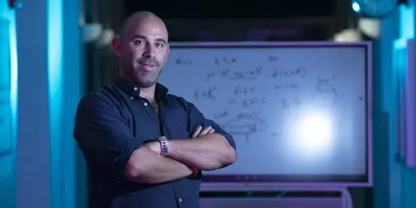 Edoardo Persichetti in front of a whiteboard with calculations on it