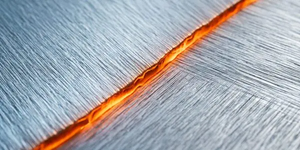 A glowing orange boundary between two brushed metal domains