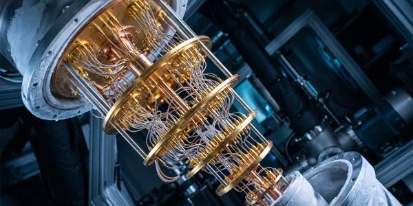 Gold cryostat stages with copper wiring spanning between frosted flanges, tilted in a lab