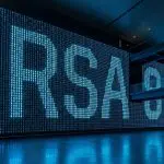 A large digital display showing the letters “RSA” is prominently displayed in a modern, expansive building with blue lighting.