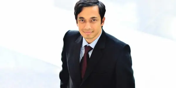 A man in a suit and tie looks up towards the camera