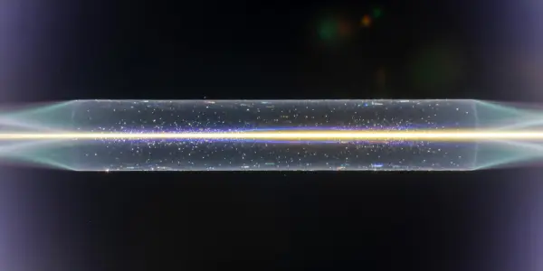 A bright, horizontal band of light and particles stretches across a dark background, with purple and white glows at each end.