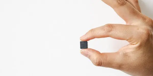 Barely larger than a fingernail: This chip is like a tiny computer. Sixty-four metal pins protrude from the black casing