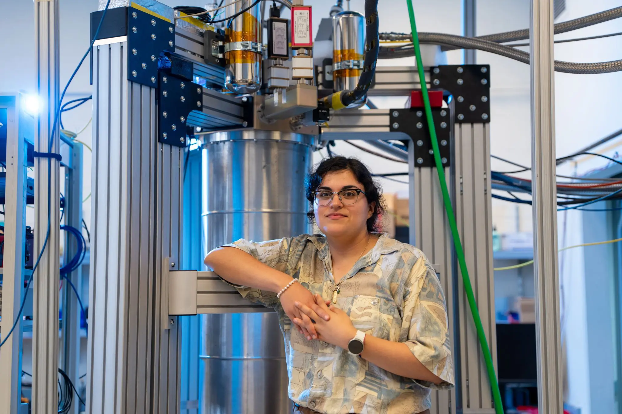 Faith Reyes stands in front of a large device in the lab
