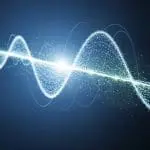 An abstract glowing blue particle waveform representing a quantum wave function on a dark background.