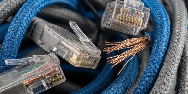 Transparent network connectors and frayed copper wire among braided blue and grey cables