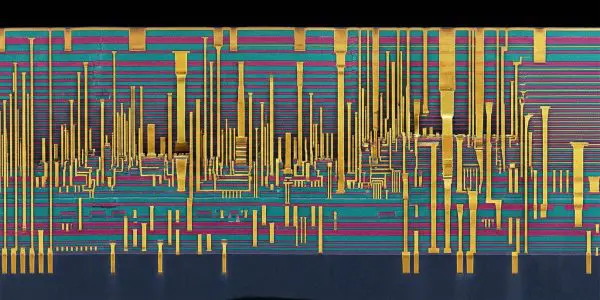 A microscopic view reveals a complex network of golden, pink and teal circuitry against a dark background