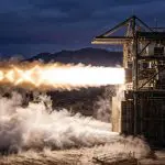 A rocket engine firing on a desert test stand