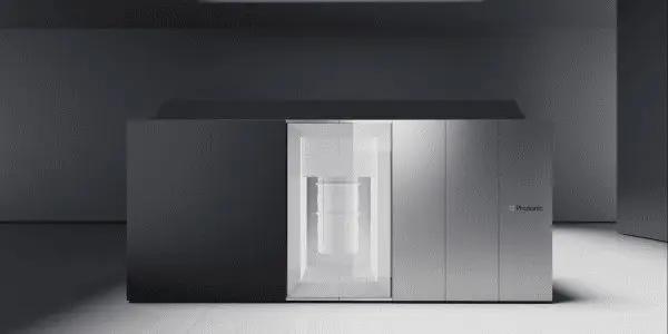 A sleek, modern 3D printer stands on a polished floor in a minimalist, dark room with grey walls.
