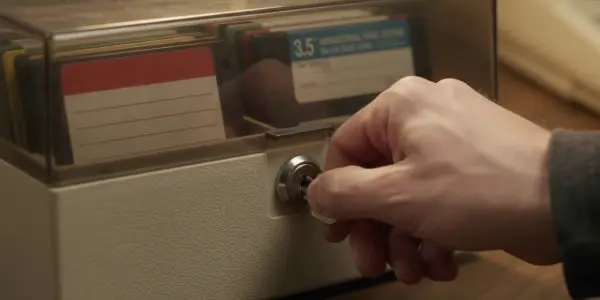 A key turning in the lock of a box of old floppy disks, an illustration of post-quantum security
