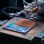 A photonic chip on a stage with a fibre array and cooling block