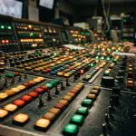 Two operators at a long lit control panel