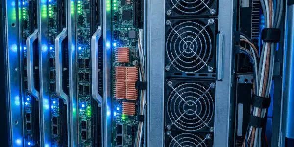 Blade server boards with blue and green status lights beside a column of cooling fans