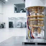 A gold-wired dilution refrigerator standing uncovered on the floor of a bright open laboratory