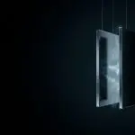 A rectangular, glowing structure hangs suspended in darkness, illuminated by cool blue light and wispy energy