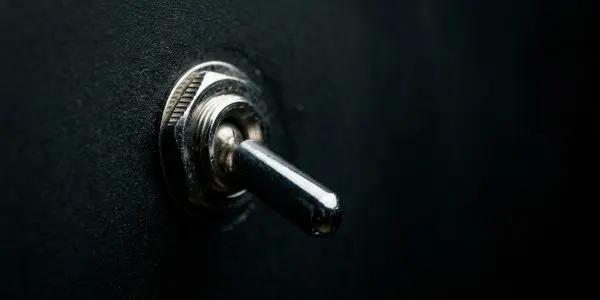 A single metal toggle switch on a dark panel