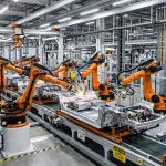 Robot arms welding car parts under factory lighting