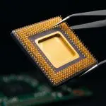 Tweezers holding a gold-lidded ceramic chip package