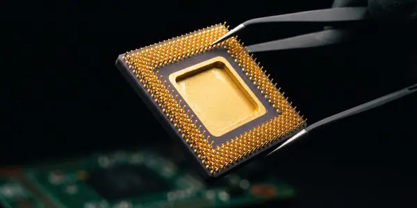 Tweezers holding a gold-lidded ceramic chip package