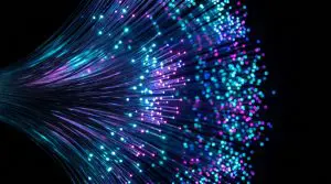 A dense array of brightly coloured optical fibers extends outwards against a dark background, creating a futuristic and dynamic visual effect.