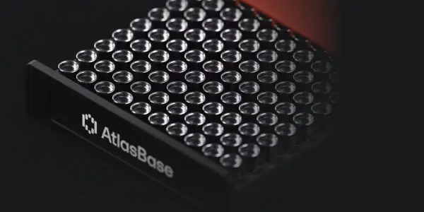 The close-up shot displays a sleek, black device with numerous circular openings, set against a dark background.