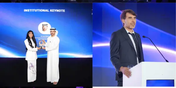 A conference setting with people in suits and traditional dress, featuring a stage and blue lighting.