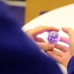 A student holding a powered-on Qbead