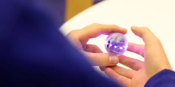 A student holding a powered-on Qbead