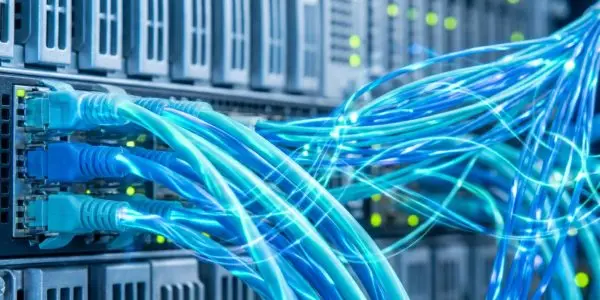 Blue and teal network cables plugged into a switch, with glowing fibre strands fanning to the right