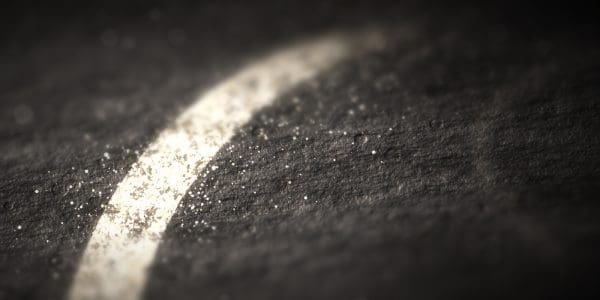 A single chalk stroke raking across dark slate