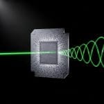 Compact photonic chip floating in deep black space, etched nanoscale waveguides glowing softly, a single coherent light beam entering and emerging with precisely rotated polarisation patterns visible as structured wavefront spirals