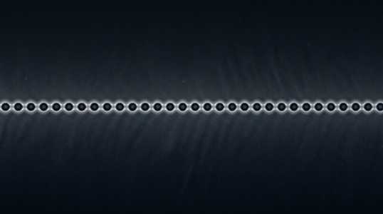 A dark grey horizontal line of evenly spaced, small, white beads stretches across a dark blue background.
