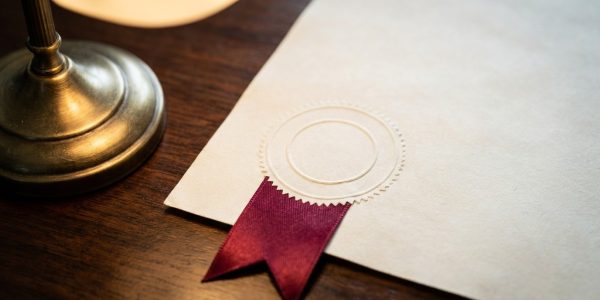 An embossed official document with a blind seal under a desk lamp